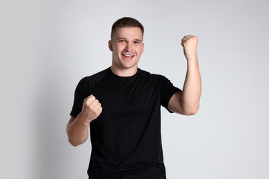 Photo of Portrait of happy winner on light grey background