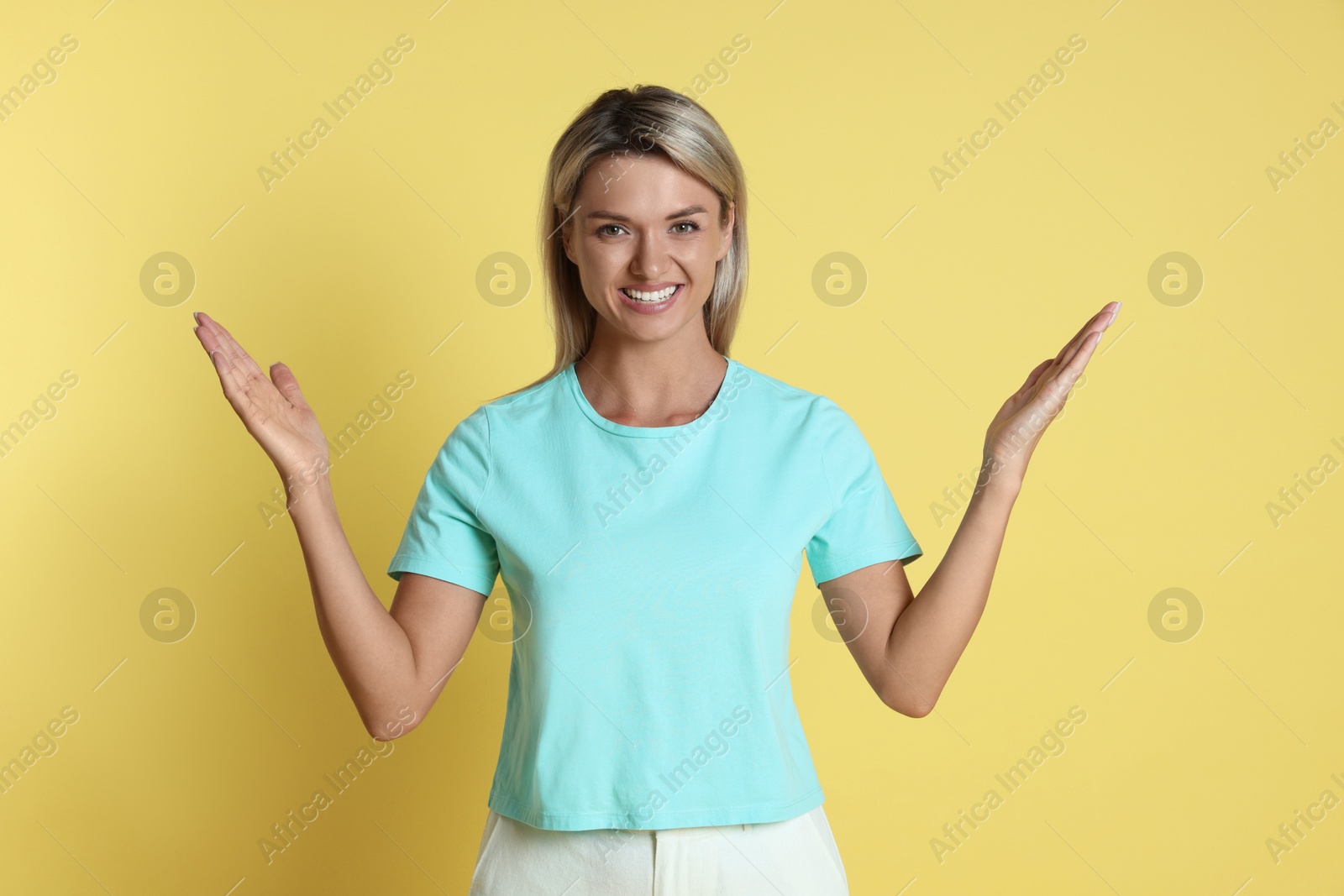 Photo of Portrait of happy winner on yellow background