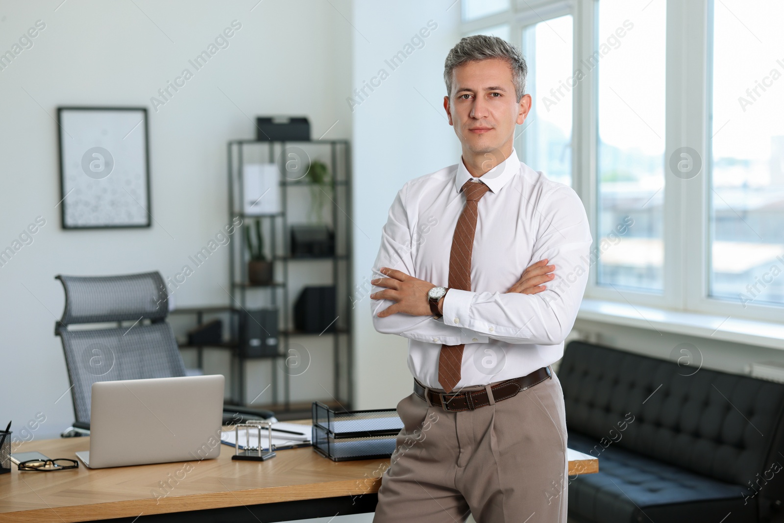 Photo of Portrait of middle aged man with crossed arms in office. Space for text