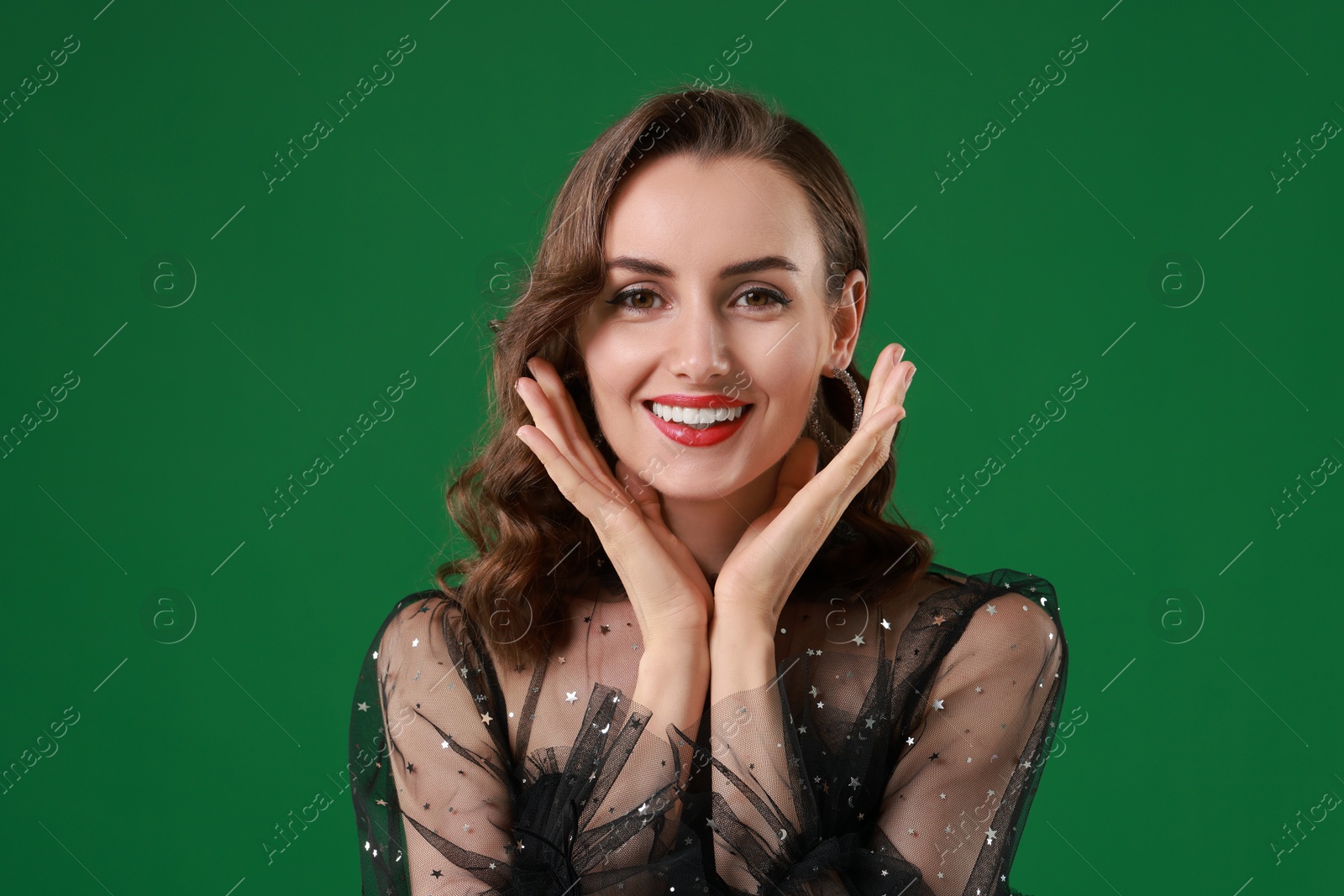 Photo of Portrait of smiling woman with perfect makeup on green background