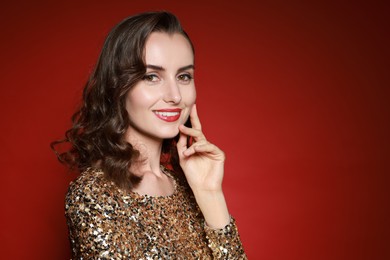 Photo of Smiling woman with perfect makeup on red background. Space for text