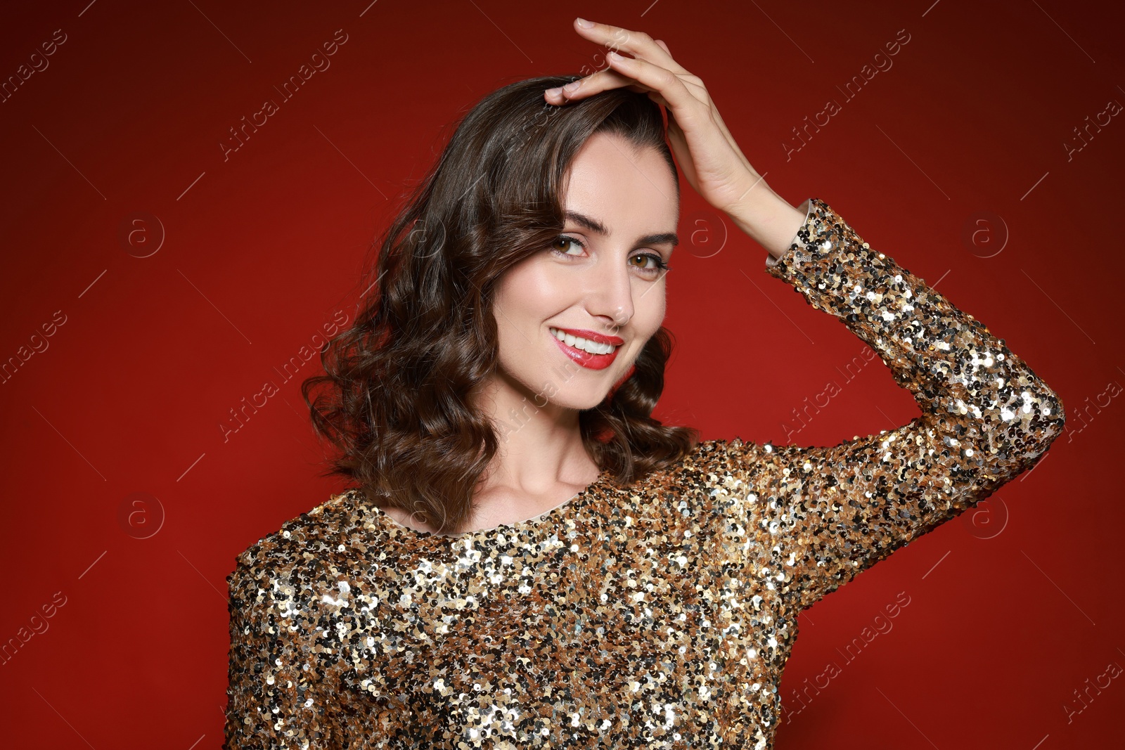 Photo of Smiling woman with perfect makeup on red background