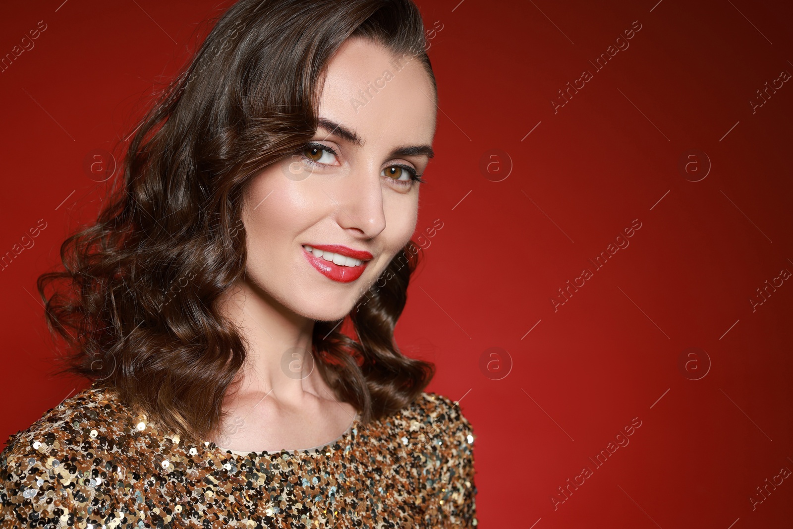 Photo of Smiling woman with perfect makeup on red background. Space for text