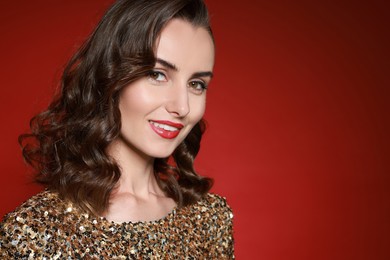 Photo of Smiling woman with perfect makeup on red background. Space for text