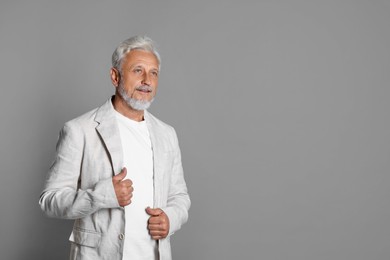 Photo of Portrait of senior man on grey background, space for text