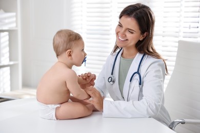 Pediatrician with little child in clinic. Checking baby's health