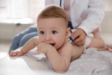 Photo of Pediatrician examining little child with stethoscope in clinic, closeup. Checking baby's health