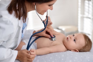 Pediatrician examining little child with stethoscope in clinic. Checking baby's health