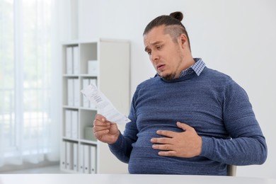 Photo of Overweight man with doctor's prescription in clinic