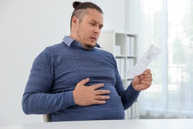 Overweight man with doctor's prescription in clinic