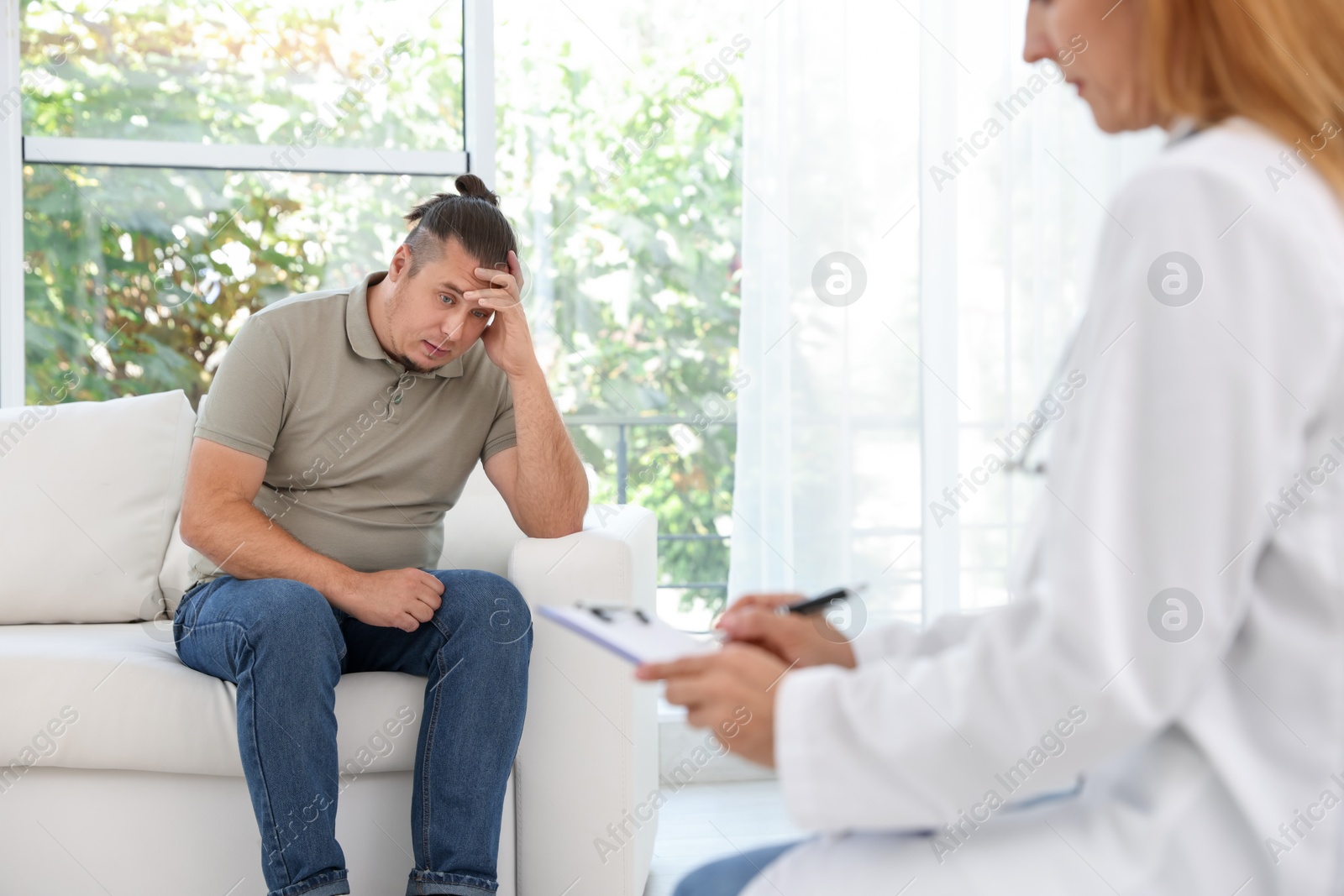 Photo of Overweight man having consultation with nutritionist in clinic, selective focus