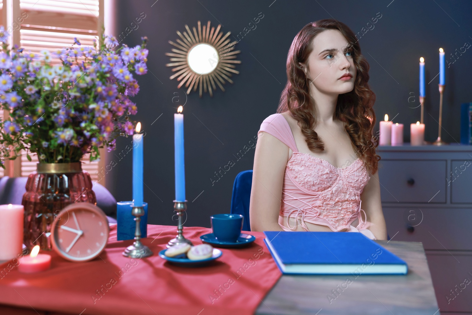 Photo of Beautiful young woman sitting at table in room. Fashion vintage style portrait