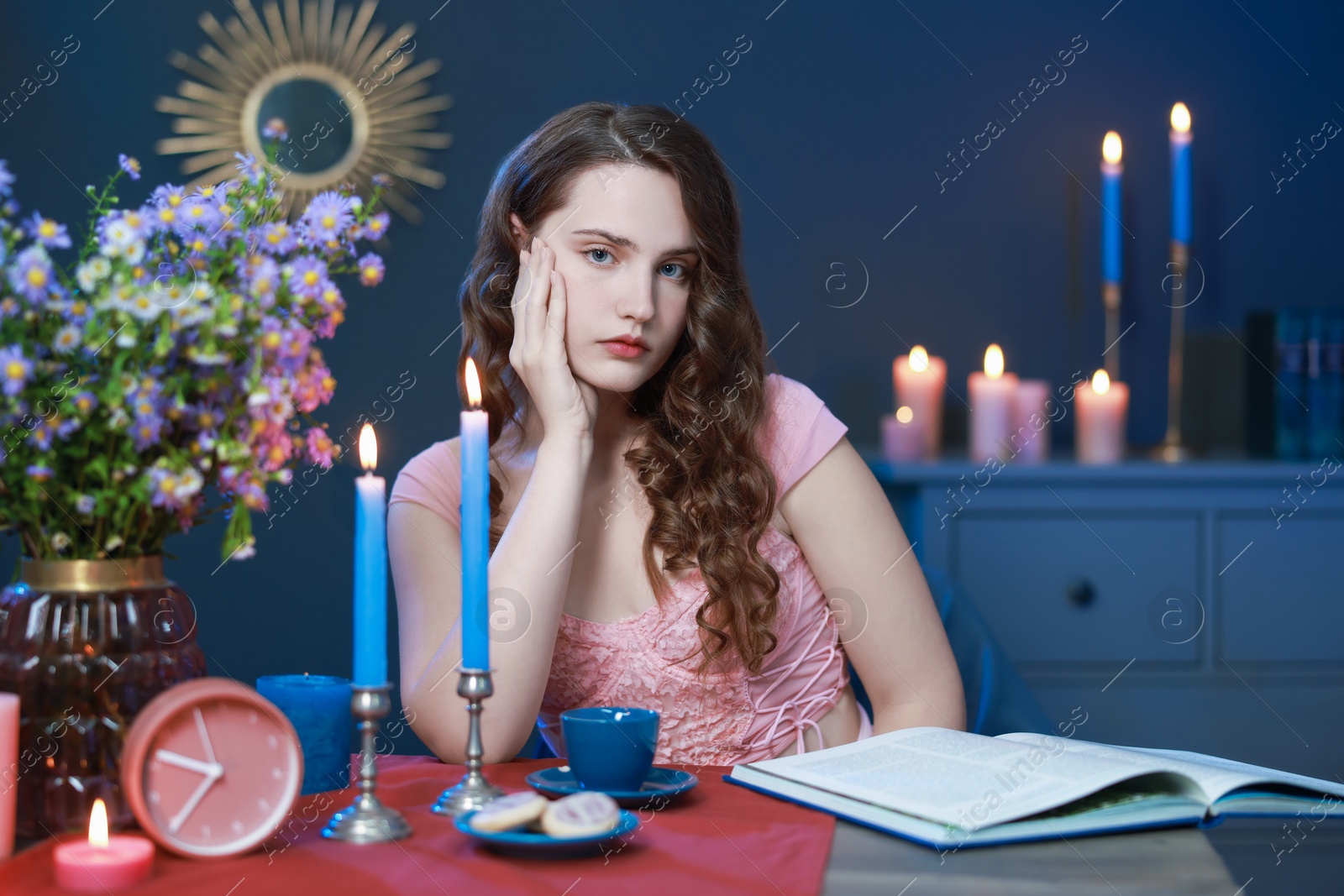 Photo of Beautiful young woman sitting at table in room. Fashion vintage style portrait