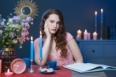 Photo of Beautiful young woman sitting at table in room. Fashion vintage style portrait