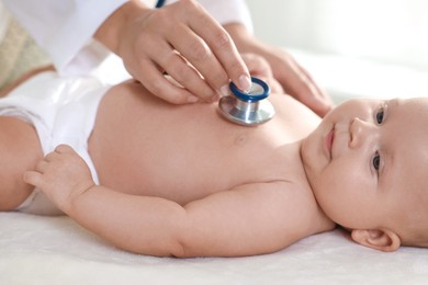 Pediatrician examining little child with stethoscope in clinic, closeup. Checking baby's health