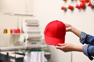 Photo of Woman with blank baseball cap for print indoors, closeup