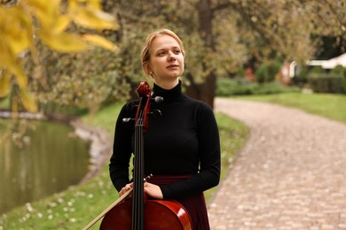 Beautiful young woman with cello in park