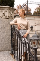 Photo of Beautiful young woman posing on stairs outdoors