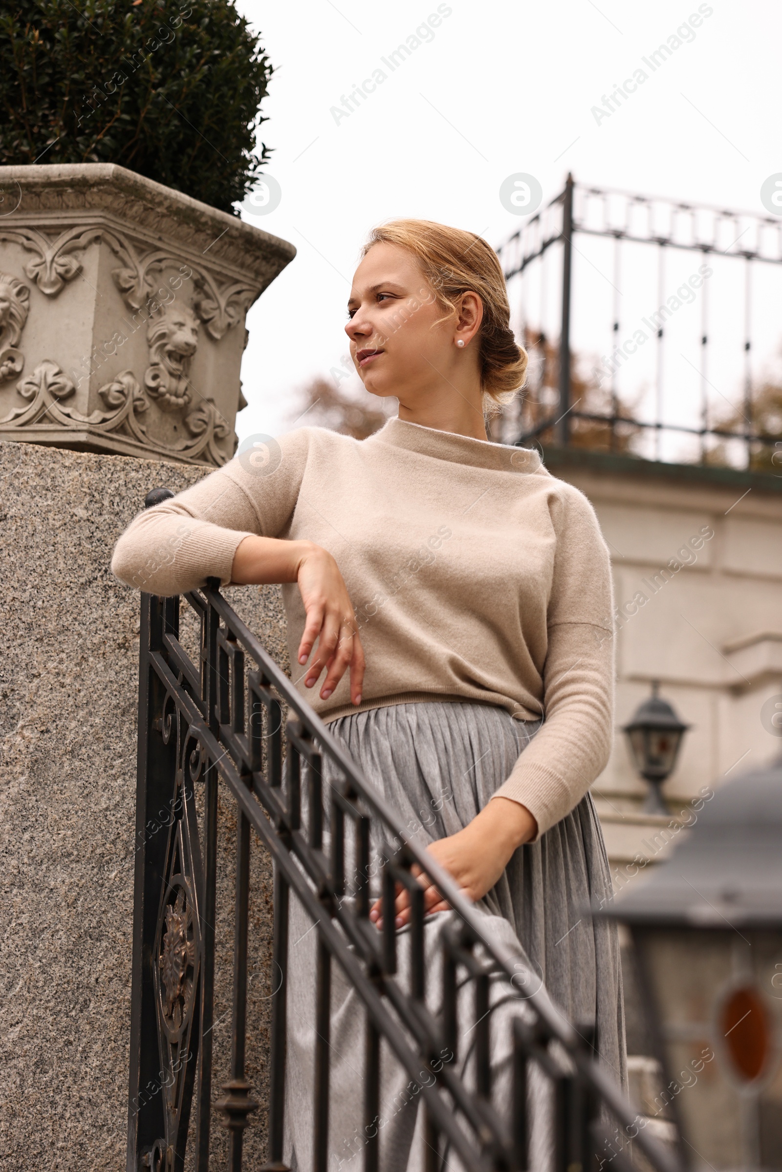 Photo of Beautiful young woman posing outdoors, low angle view