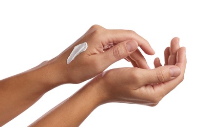 Woman applying cream onto hand on white background, closeup