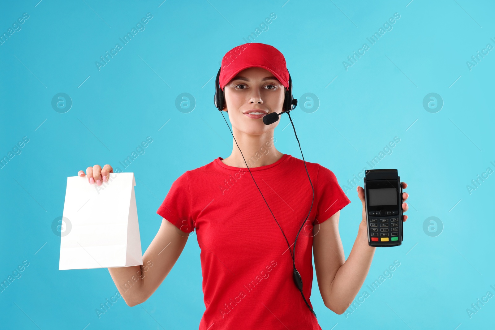 Photo of Fast-food worker with paper bag and payment terminal on light blue background