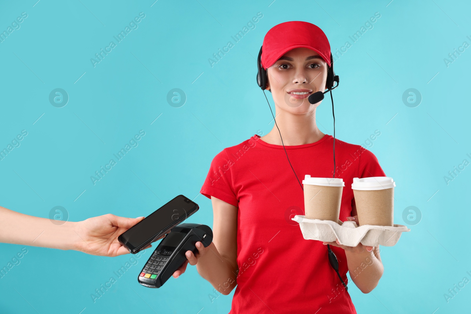 Photo of Fast-food worker taking payment from client via terminal on light blue background, closeup