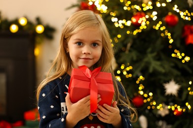 Little girl with Christmas gift at home