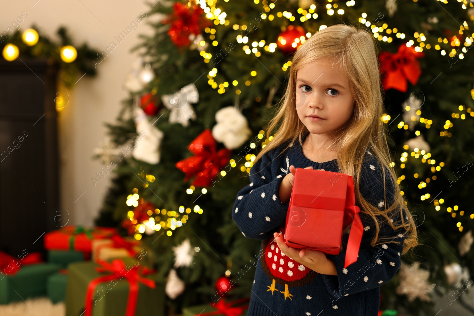 Photo of Little girl with Christmas gift at home