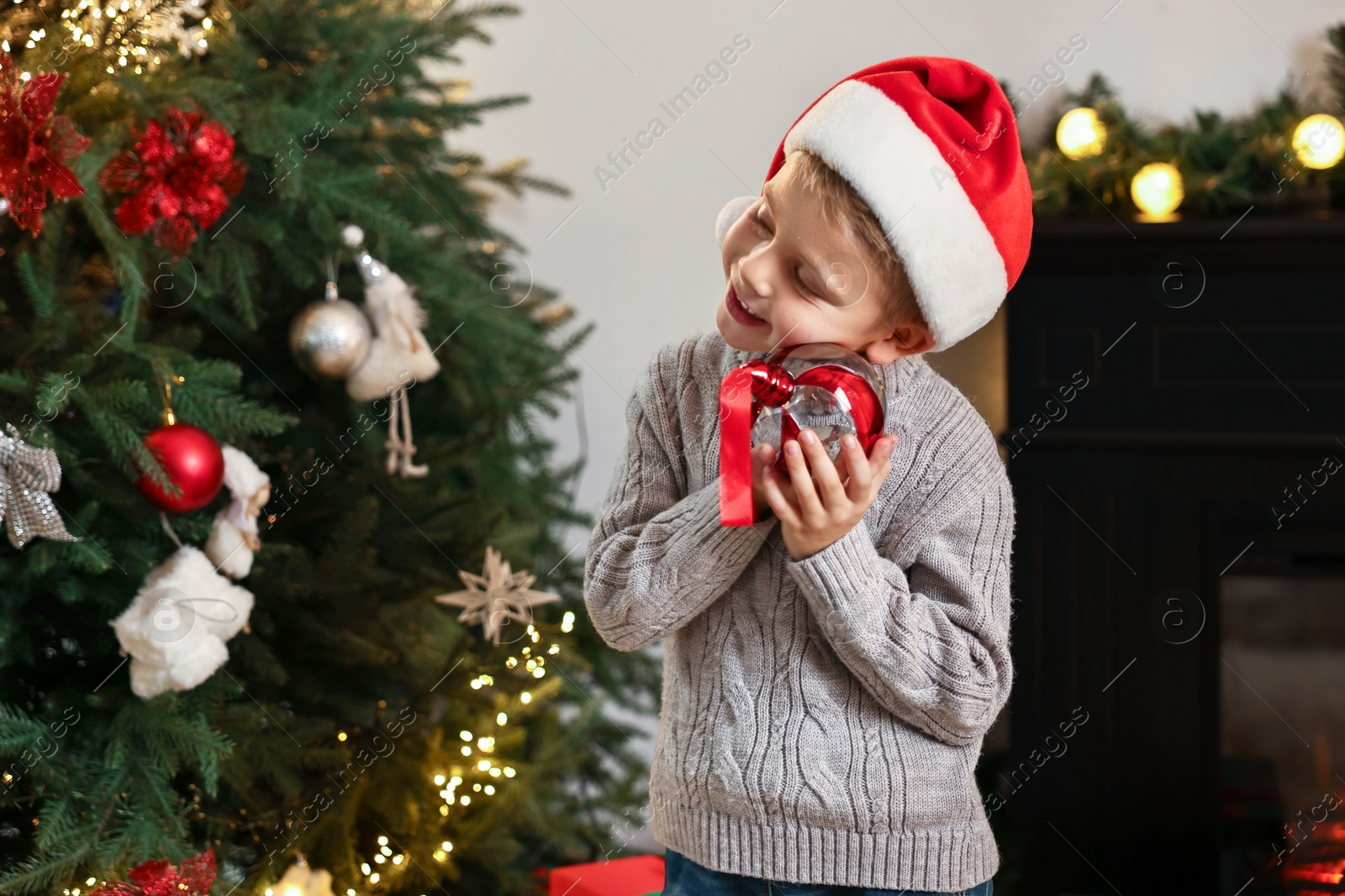 Photo of Little boy with Christmas ornament at home