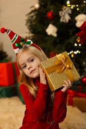 Photo of Little girl with Christmas gift at home