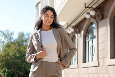 Photo of Portrait of young woman wearing stylish suit outdoors