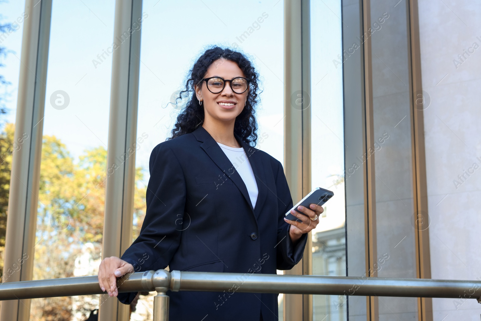 Photo of Portrait of young woman with phone wearing stylish suit outdoors