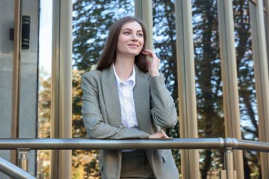 Photo of Portrait of young woman wearing stylish suit outdoors