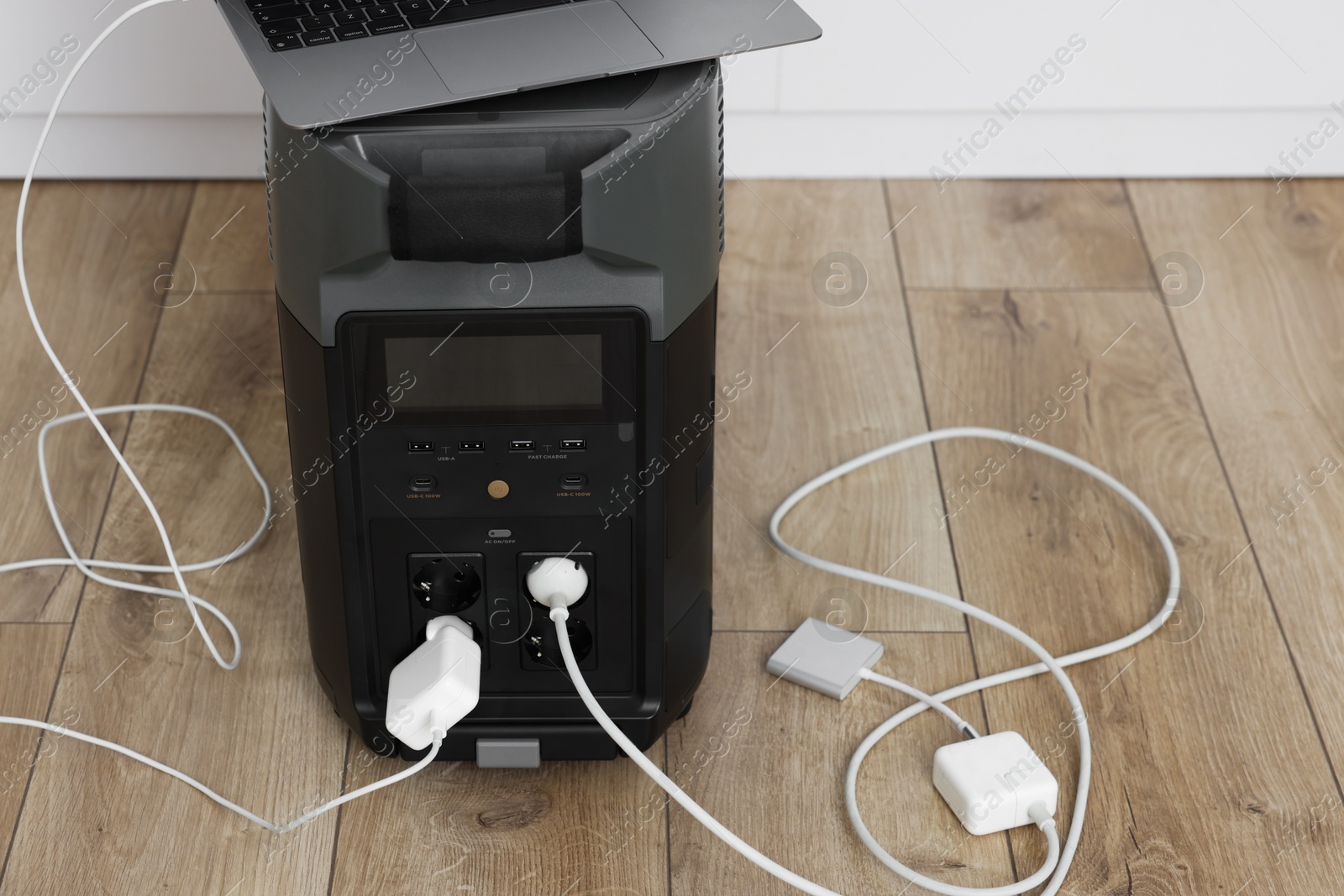 Photo of Modern portable power station, charging attached devices indoors