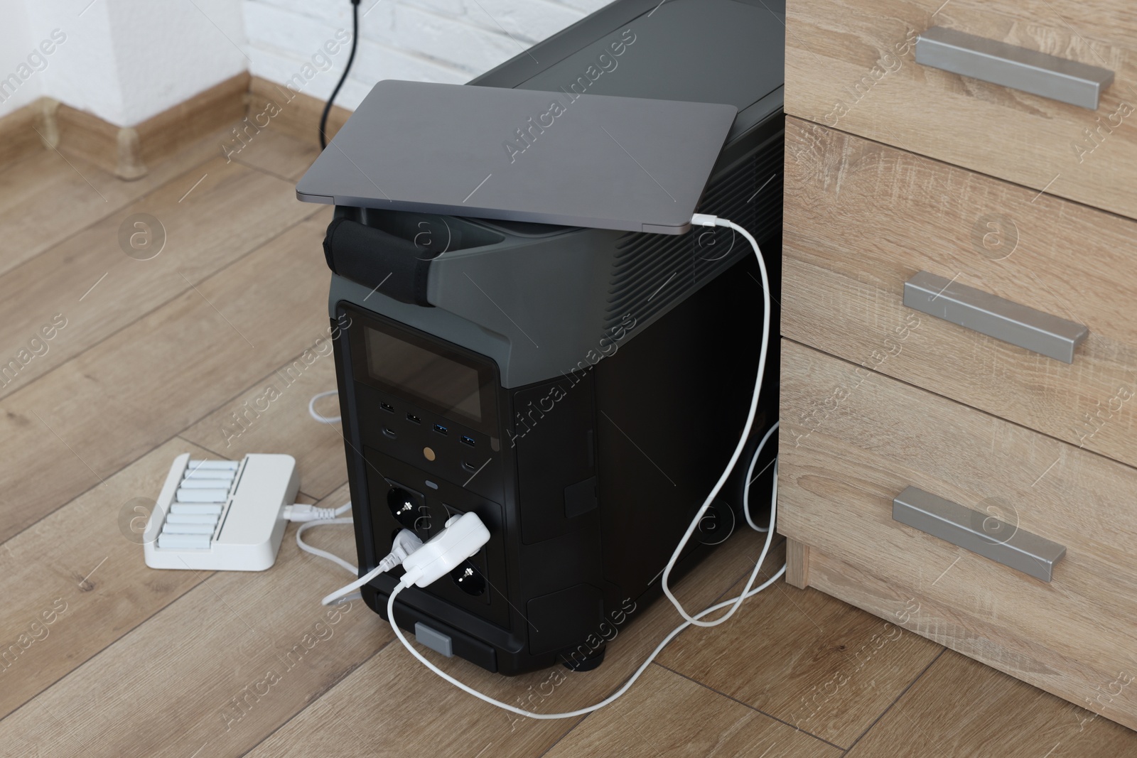 Photo of Modern portable power station, charging attached devices indoors