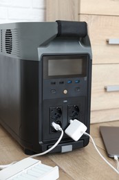 Photo of Modern portable power station, charging attached devices indoors