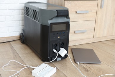 Photo of Modern portable power station, charging attached devices indoors