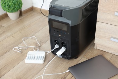 Photo of Modern portable power station, charging attached devices indoors