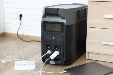 Photo of Modern portable power station, charging attached devices indoors