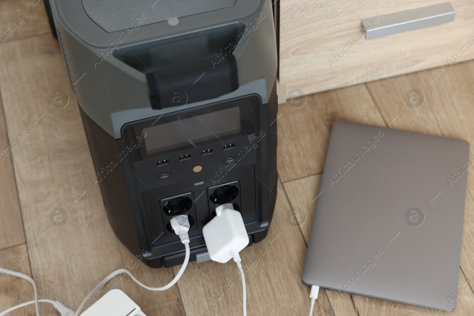 Photo of Modern portable power station, charging attached devices indoors