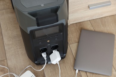 Photo of Modern portable power station, charging attached devices indoors