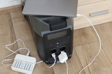 Photo of Modern portable power station, charging attached devices indoors