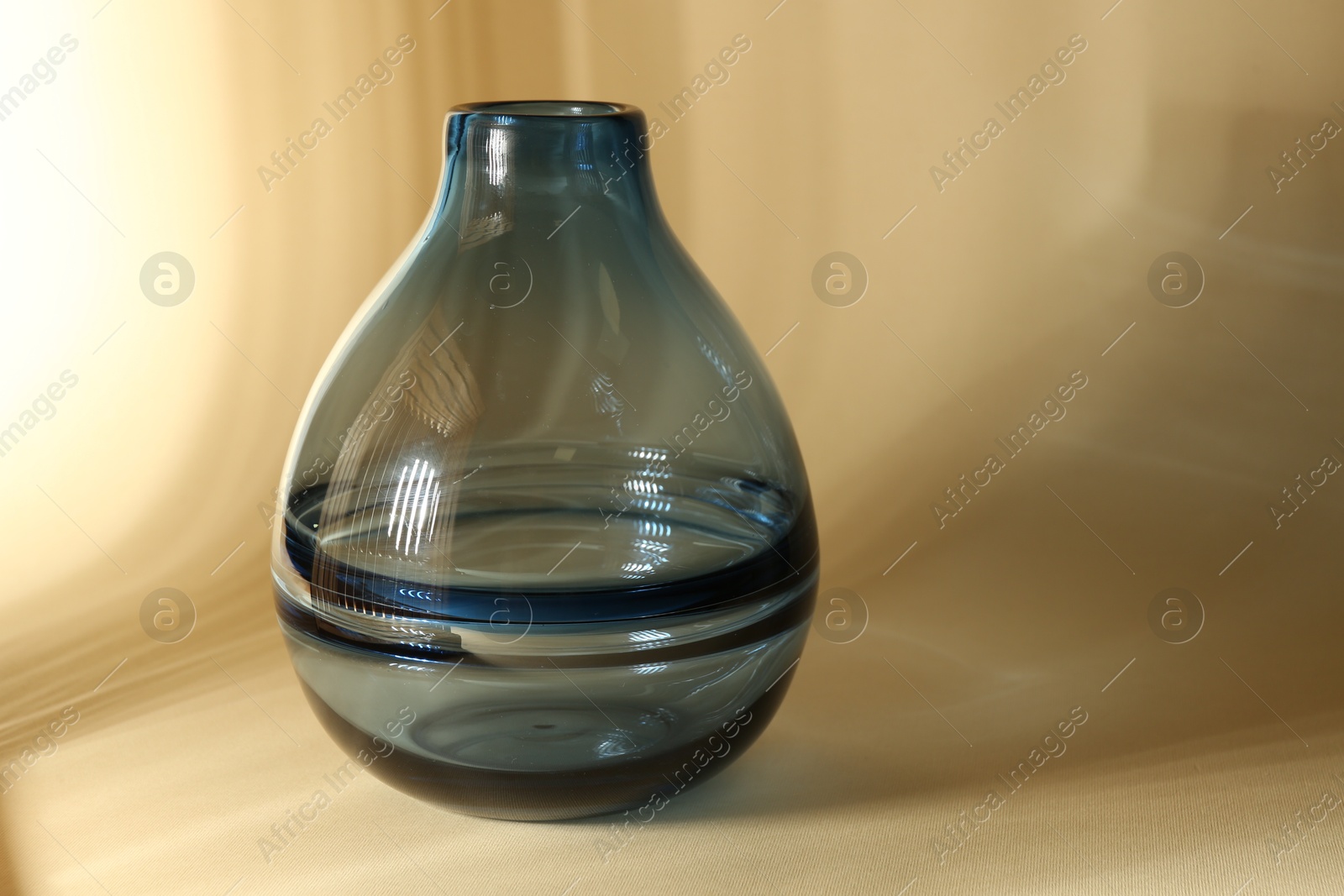 Photo of Empty glass vase on beige background, space for text