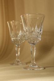 Photo of Two empty wine glasses on beige background