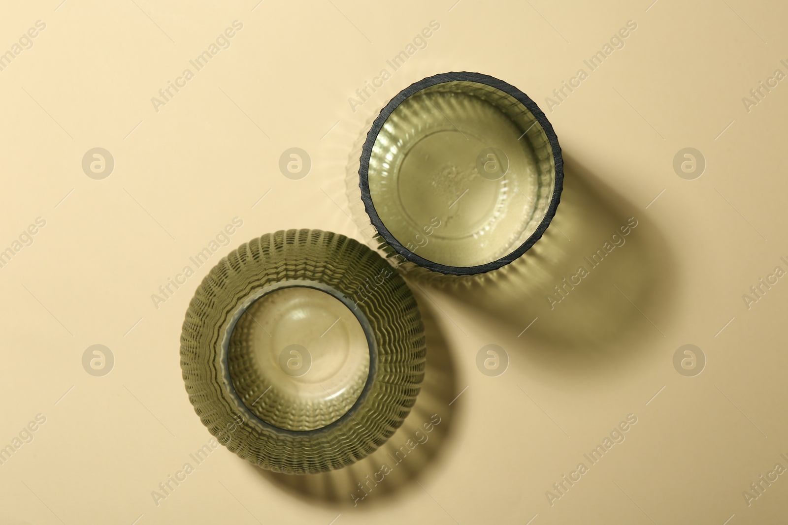 Photo of Empty glass vases on beige background, flat lay