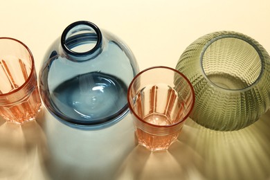 Photo of Empty glass vases on beige background, above view