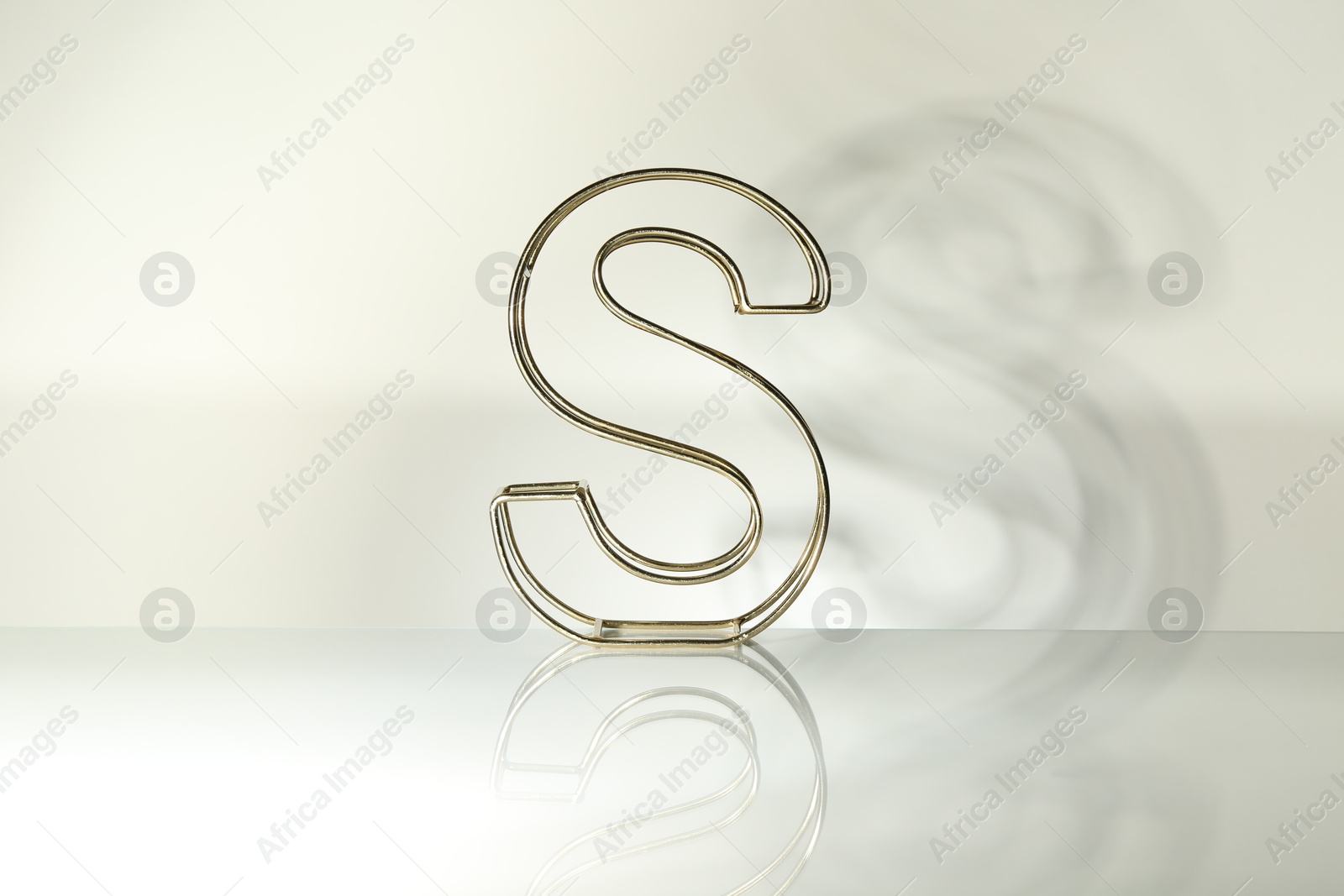 Photo of Stylish golden decor in shape of letter S on white background