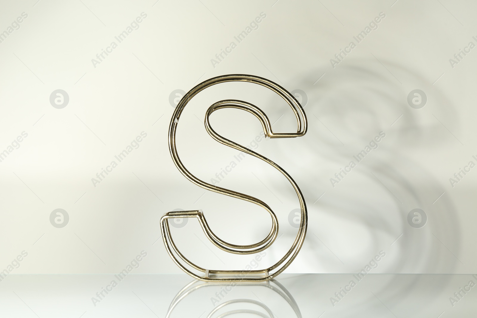 Photo of Stylish golden decor in shape of letter S on white background