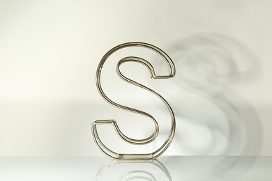 Photo of Stylish golden decor in shape of letter S on white background