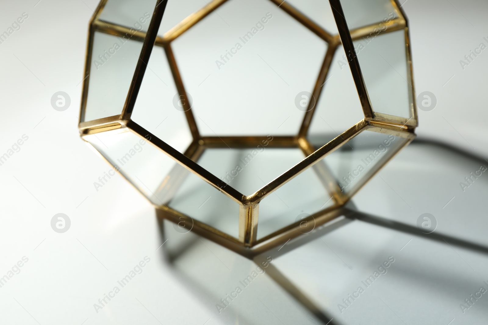 Photo of Stylish golden decor casting beautiful shadows on white table, closeup